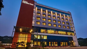 A multi-story hotel with a prominent red and blue facade, large windows, and a well-lit entrance area. - Hilton Garden Inn Lucknow (Lucknow)
