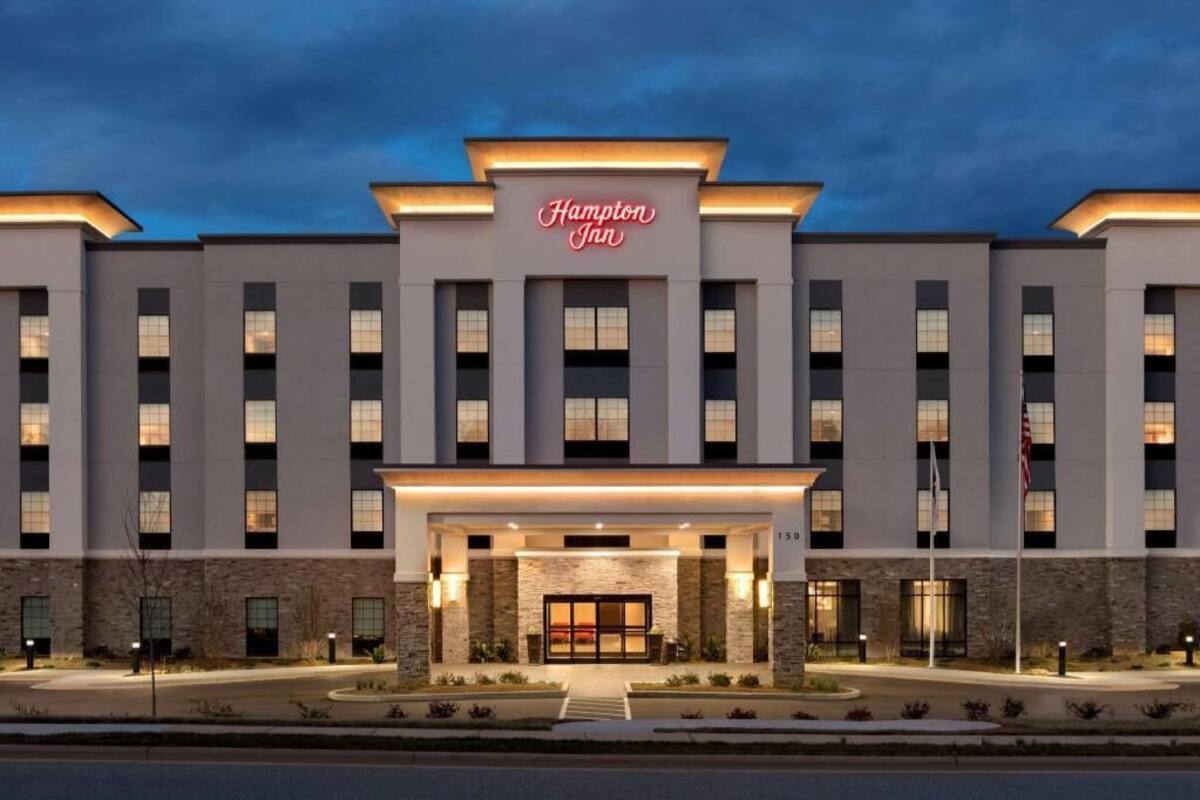 A Hampton Inn hotel with a modern facade, a prominent entrance, and a well-lit exterior.