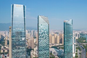 Três edifícios altos com fachadas de vidro refletivo, um deles com a inscrição