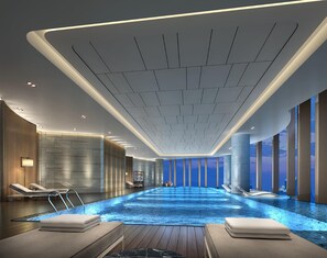 A modern indoor swimming pool with a clear view of the sky through large windows, surrounded by lounge areas with towels. - Hilton Fuzhou (Fuzhou)