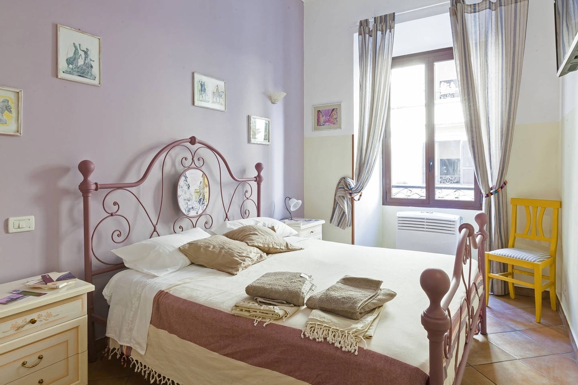 A bedroom with a bed, bedside tables, a chair, and a window with curtains.