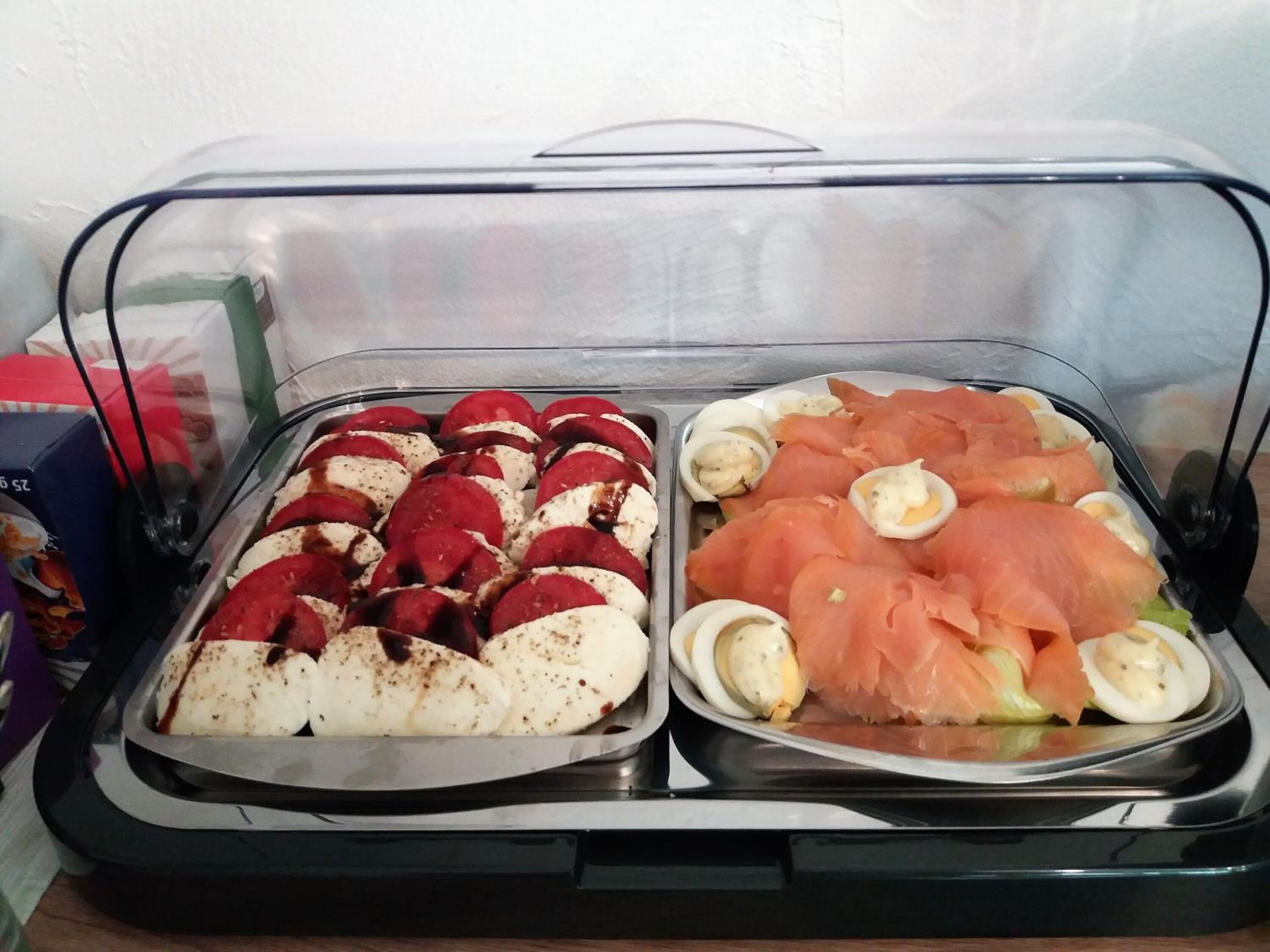 Ein Buffet mit aufgeschnittenem rotem Fleisch, weißem Käse, Lachs und hartgekochten Eiern.