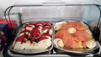 Ein Buffet mit aufgeschnittenem rotem Fleisch, weißem Käse, Lachs und hartgekochten Eiern.