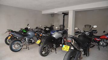A parking area with multiple motorcycles, each with a visible license plate.