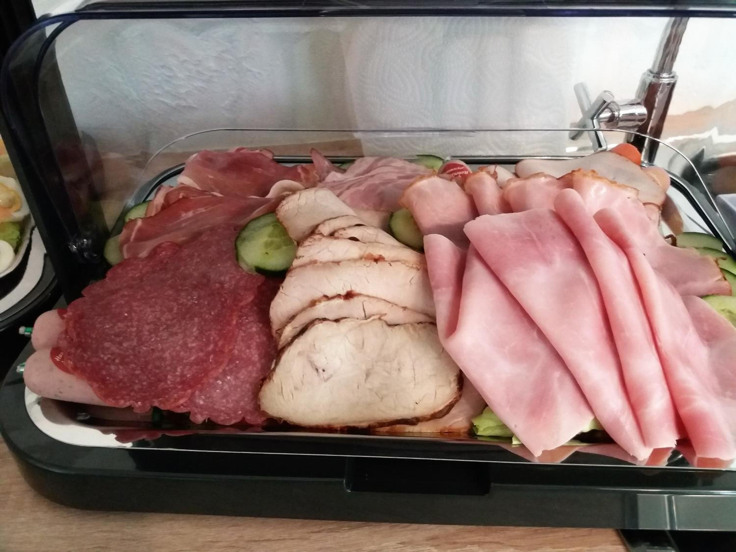Un expositor de vidrio con diversos tipos de carne y verduras.