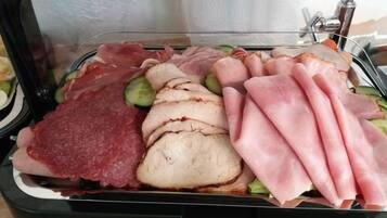 Un expositor de vidrio con diversos tipos de carne y verduras.