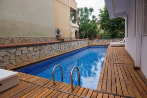 Piscine extérieure, parasols de plage, chaises longues