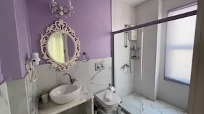 A bathroom with a vanity, a toilet, a shower, and a mirror with an ornate frame. - Kiraz Cicegi Butik Akyaka (Ula)