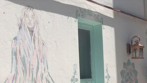 Pared con un mural que muestra una figura, una puerta y un farol.