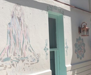 Pared con un mural que muestra una figura, una puerta y un farol.