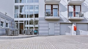 A modern building with a courtyard, outdoor seating, and a fire alarm box. - Hotel Neckarlux (Heidelberg)