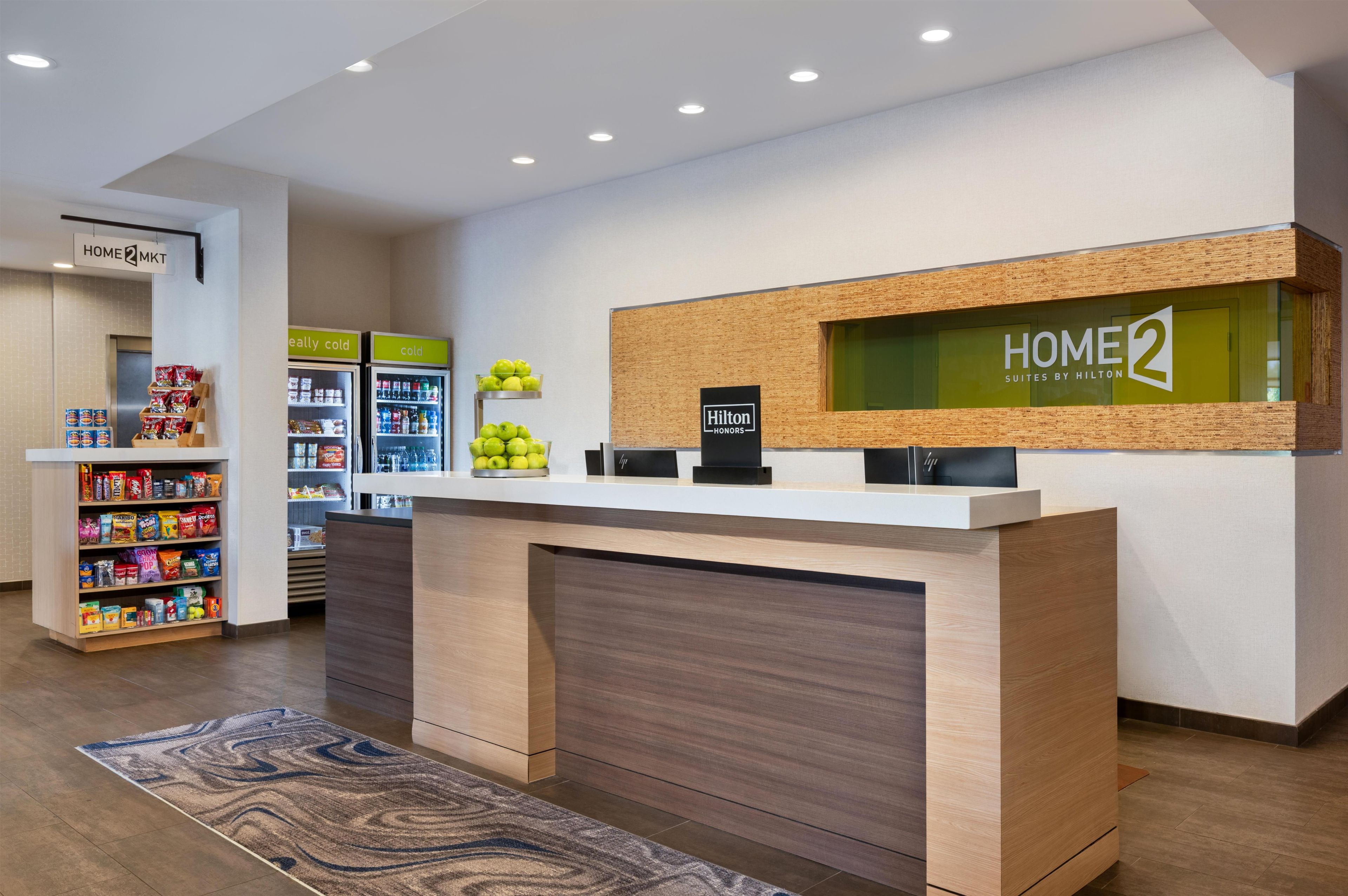 A hotel reception area with a counter, vending machines, and a display of fruits.