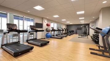 A gym with treadmills, exercise balls, and weight machines.