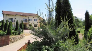 A two-story building with a stone wall and a wooden fence in front. - Kolpinghaus (Caransebes)