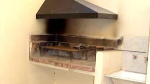 Un four extérieur en briques, doté d’une hotte noire, probablement utilisé pour la cuisson ou la grillade.