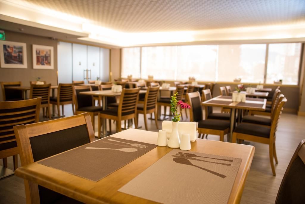A restaurant with multiple tables and chairs, arranged in a spacious layout.