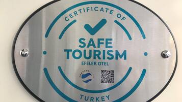 Un letrero circular con el texto 'CERTIFICATE OF SAFE TOURISM' y 'TURKEY'.