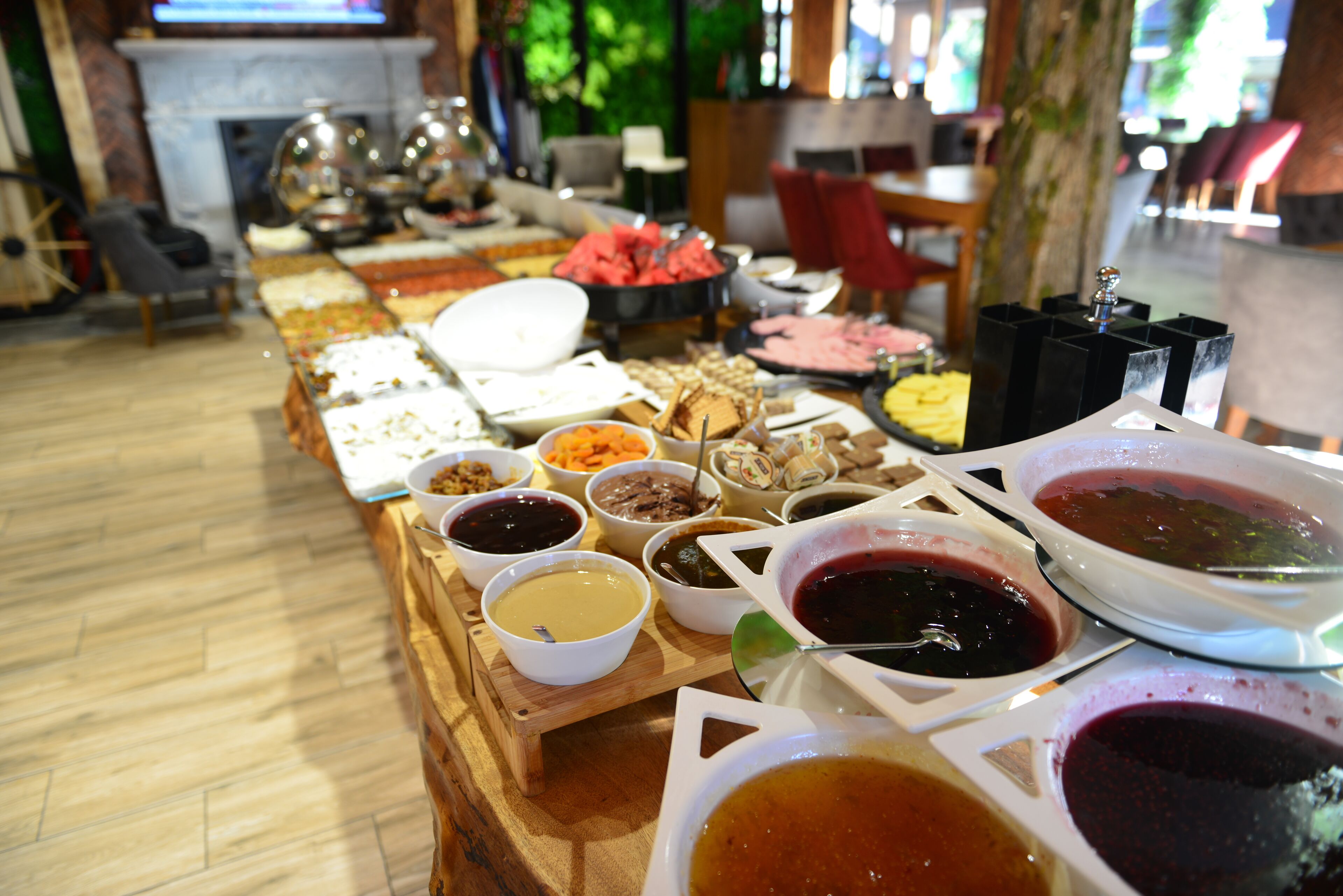 A buffet table with various food items and condiments.