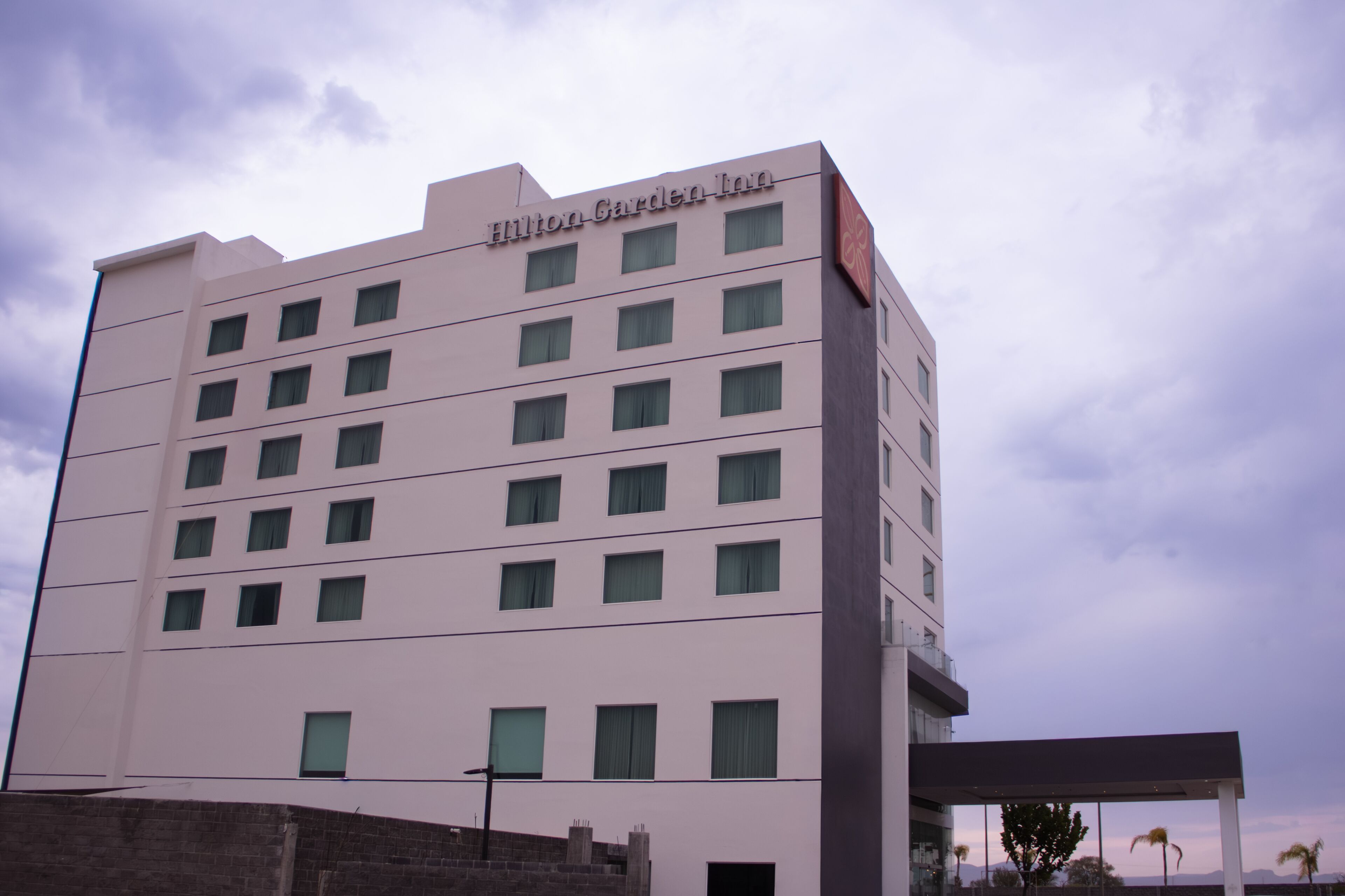 A multi-story building with the name "Hilton Garden Inn" on the facade.