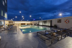 Una piscina al aire libre, sillones reclinables de piscina