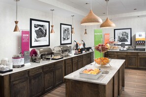 Una barra de desayuno con diversas opciones de comida y una estación de café.