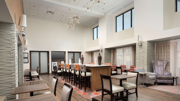 A spacious hotel lobby with high ceilings, modern chandeliers, and a mix of seating options including tables and chairs. - Hampton Inn & Suites San Antonio Lackland AFB SeaWorld (San Antonio)