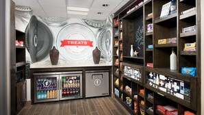A snack bar with a 'Treats' sign, refrigerated drinks, and shelves stocked with snacks and candies. - Hampton Inn & Suites San Antonio Lackland AFB SeaWorld (San Antonio)