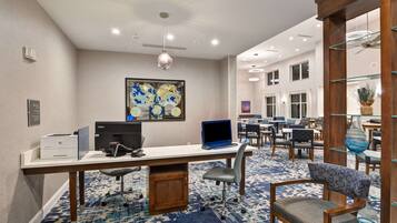 A hotel room with a desk, chair, and a large map on the wall.