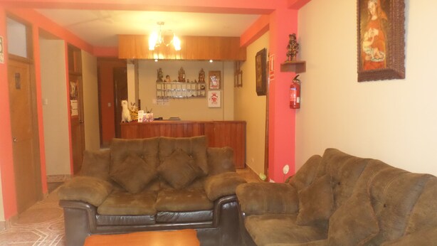 A living room with two brown sofas, a wooden coffee table, and a fireplace. - Hatun Pueblo Inn (Machu Picchu)