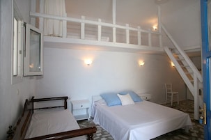 Un dormitorio con dos camas, una escalera y una silla pequeña.