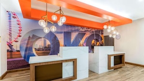 Un espace d’accueil doté de comptoirs en marbre, d’une grande fresque murale et d’un plancher en bois.