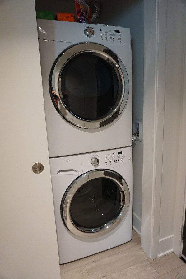 Une machine à laver et un sèche-linge superposés dans une buanderie.