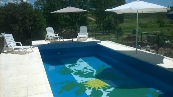 Piscine extérieure, parasols de plage, chaises longues