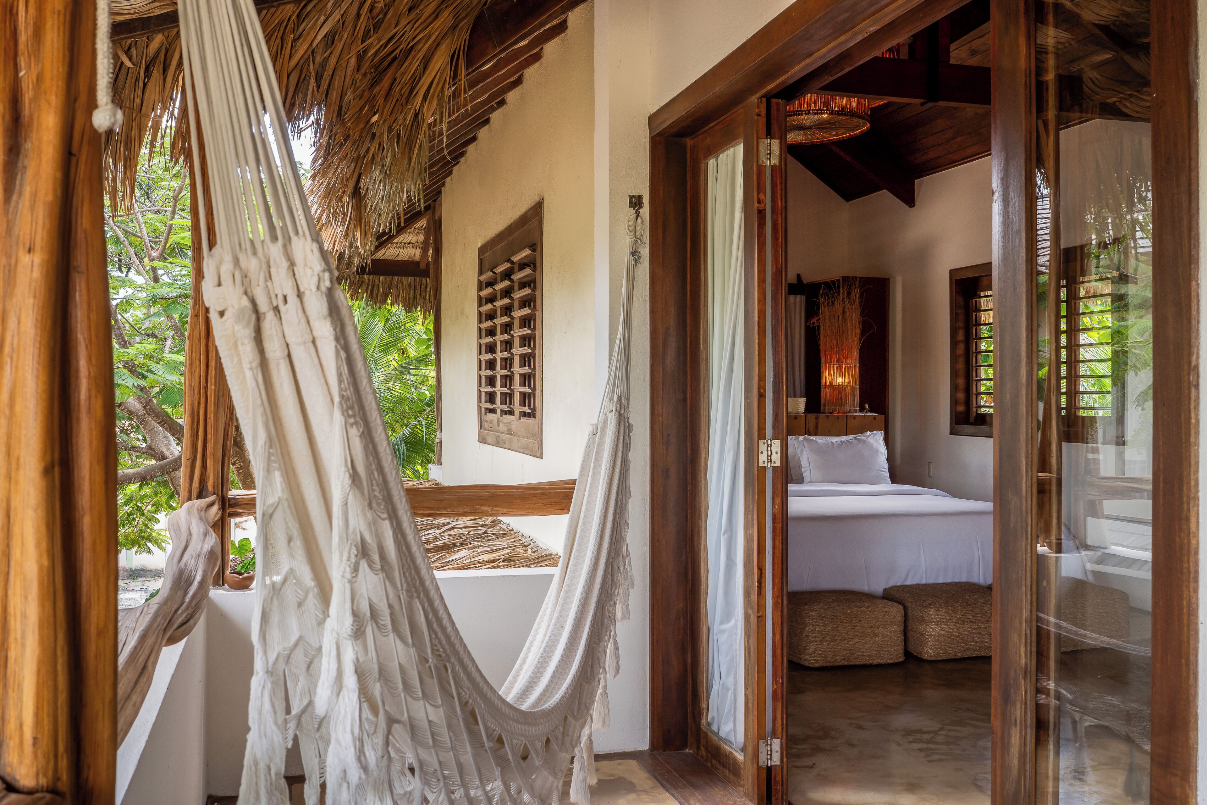 Una habitación con cama, una hamaca y vista a zonas verdes.