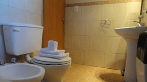 Une salle de bain comprenant des toilettes, un bidet et un lavabo.