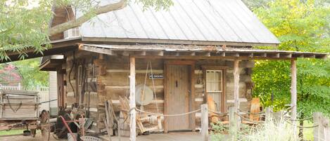 A rustic log cabin with a porch, a swing, and a 'No Smoking' sign.
