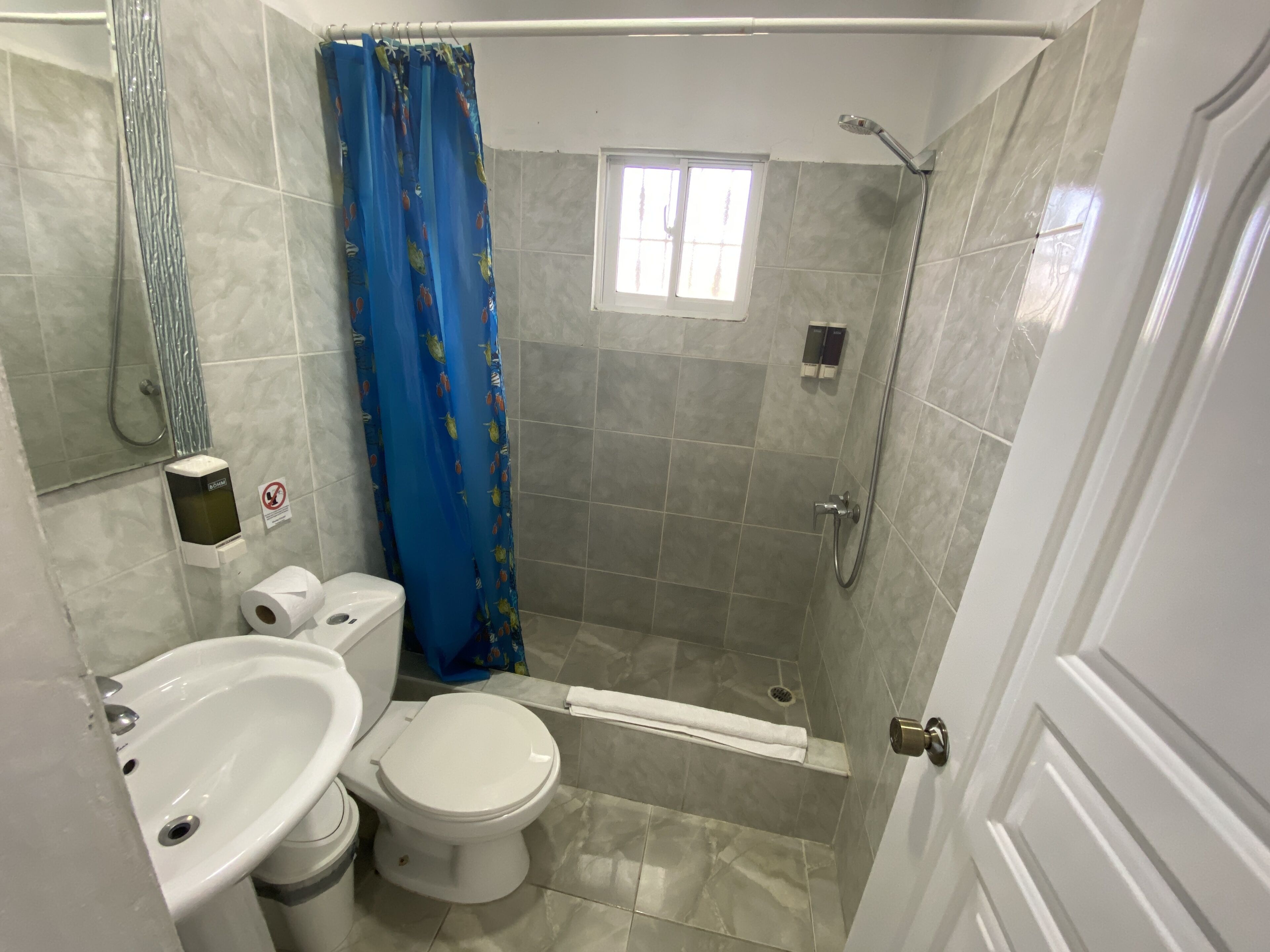 Un baño con inodoro, bidé y ducha.