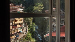 Habitación con un ventanal grande que da a un paisaje montañoso, una escalera y vistas de un río.