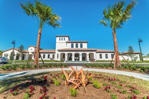 A building with a white facade, a central entrance, and a symmetrical design. - Windsor at Westside Resort Homes (Kissimmee)