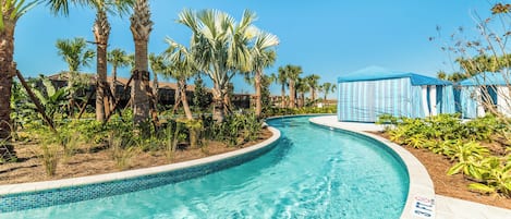A swimming pool with a curved edge, surrounded by palm trees and a blue-roofed structure.