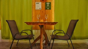 A wooden table with two chairs, a sign indicating WiFi availability, and a welcome sign. - Casa Campo Verde (Monteverde)