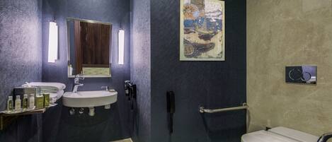 A modern bathroom with a dark blue wall, a white sink, a mirror, a telephone, and a toilet.