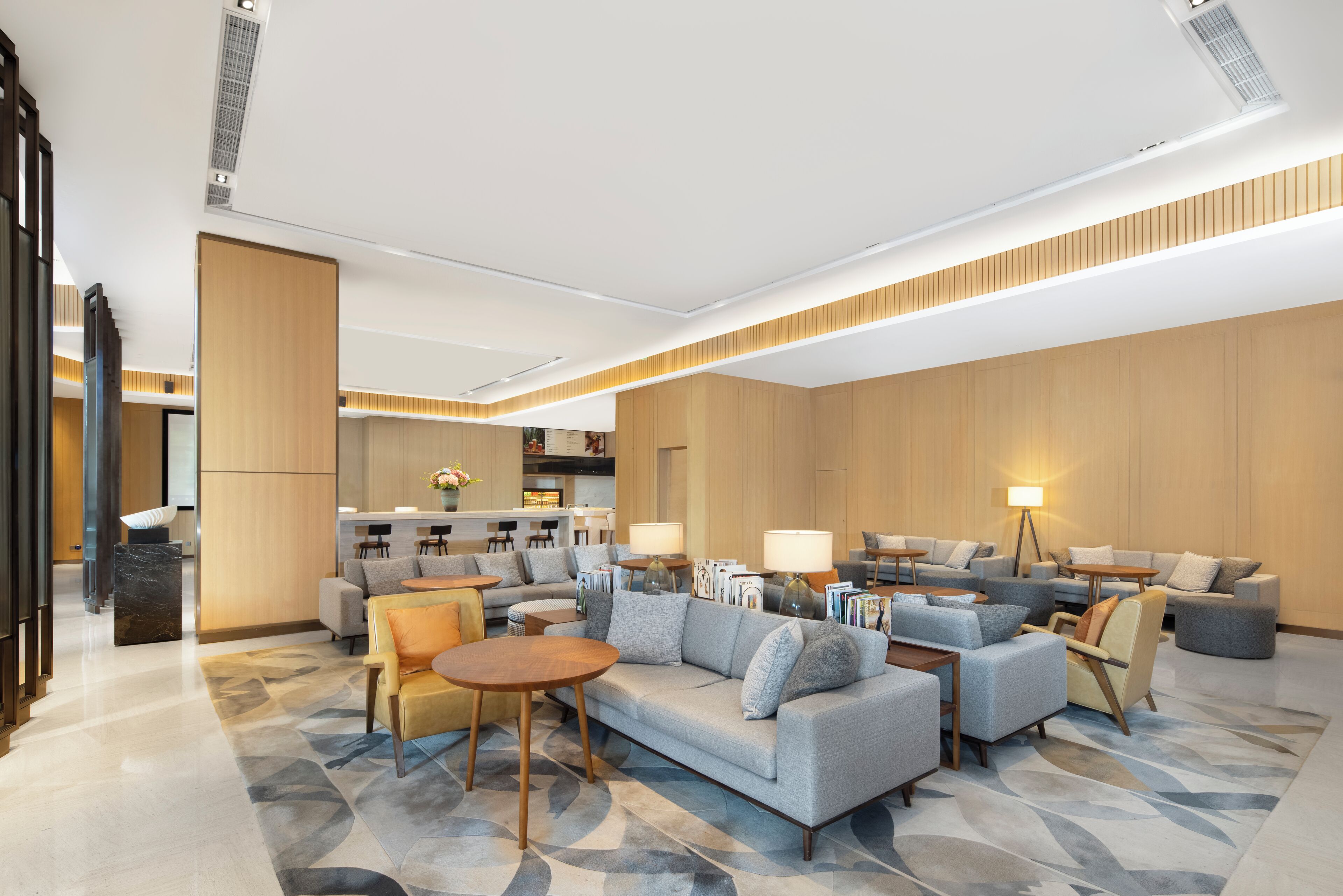 Eine moderne Hotelhalle mit einer großen Sitzecke, einer Küche und einer Rezeption.