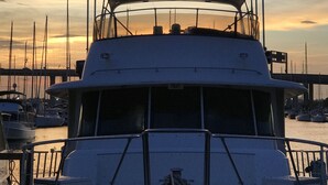 A boat docked at a marina with a sunset in the background. - Southern Comfort Yacht (Charleston)