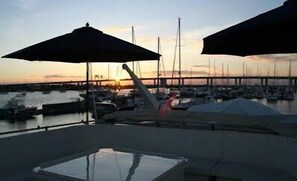 A marina with boats docked, a pier in the background, and umbrellas providing shade. - Southern Comfort Yacht (Charleston)