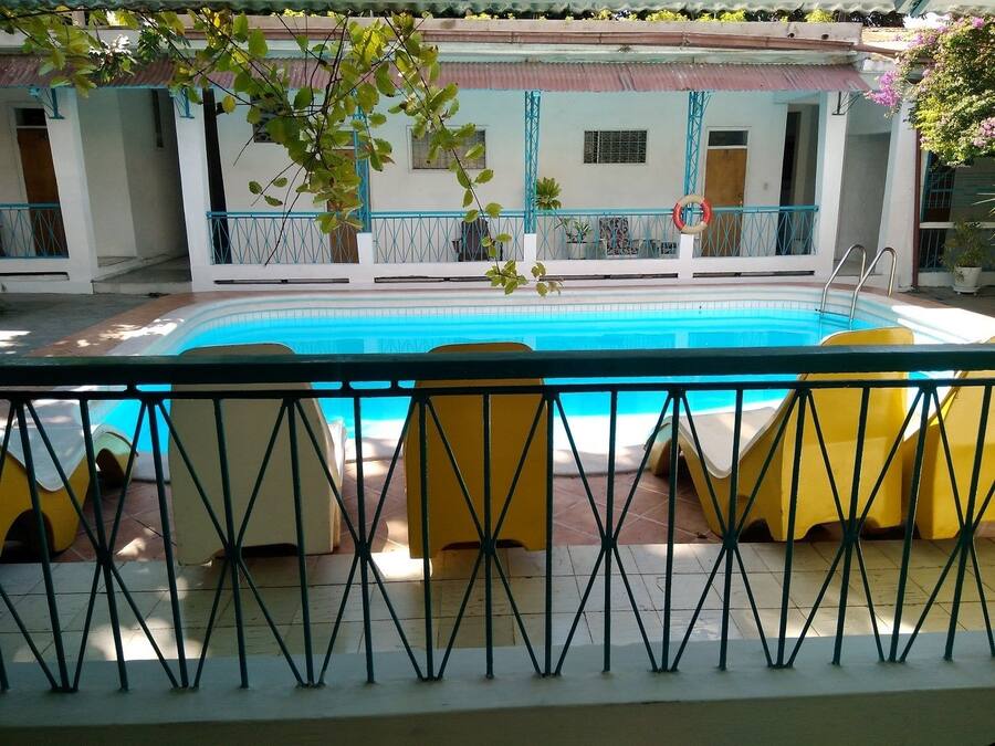 A poolside area with yellow lounge chairs and a metal railing.