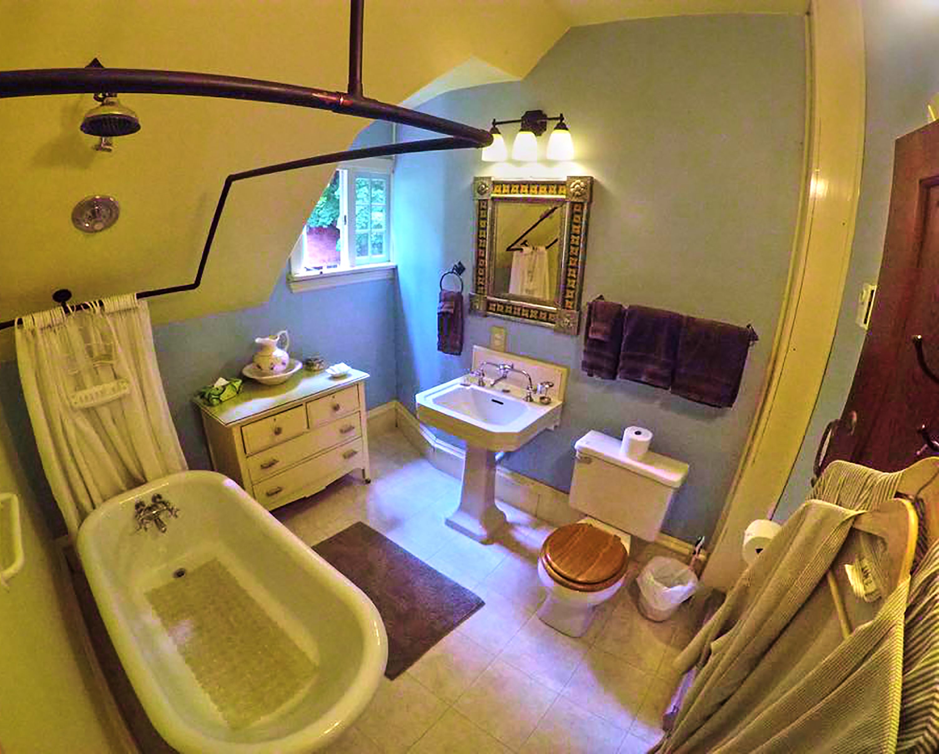 A bathroom with a bathtub, sink, toilet, and a shower area.