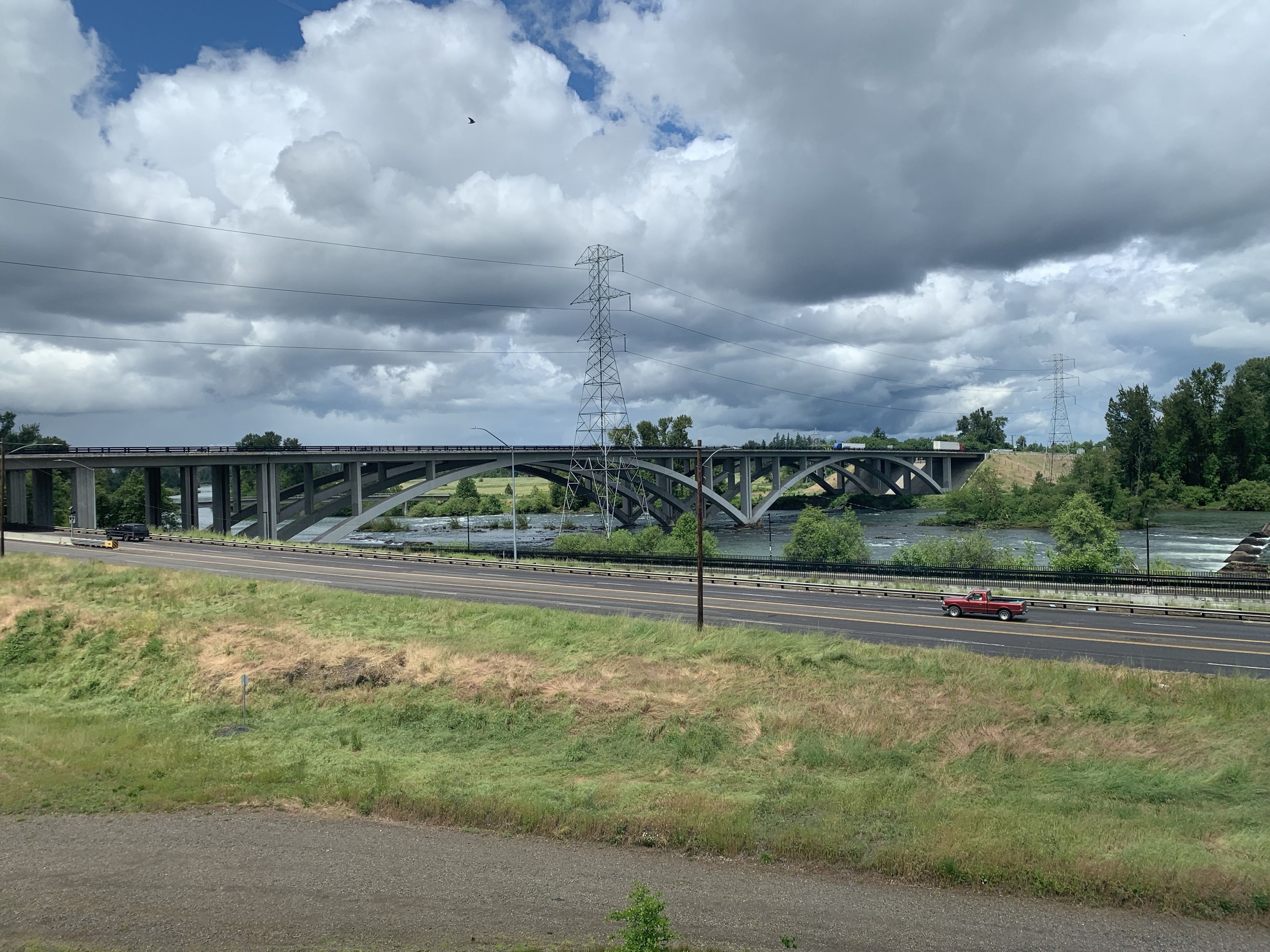 A bridge over a river with a road running parallel to it.