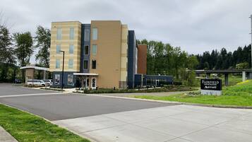 A modern multi-story hotel with a flat roof and a sign indicating Fairfield Inn & Suites by Marriott.