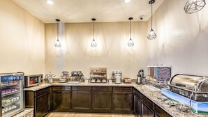 Uma cozinha moderna com bancada de granito, eletrodomésticos embutidos e iluminação pendente.